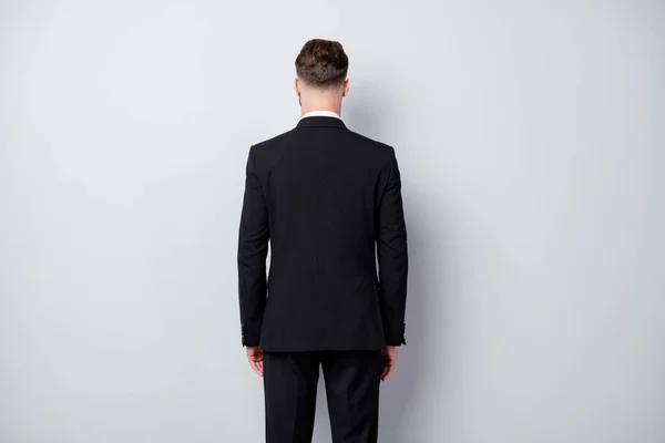 Espina dorsal trasera foto de estricto empresario serio hombre de pie detrás de la vista usando ropa formalwear aislado sobre fondo de color gris — Foto de Stock