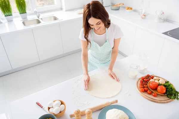 Foto van mooie vrolijke huisvrouw genieten hobby bereiden familie recept diner vormen maken deeg voor pizza moderne keuken binnen casual kleding — Stockfoto