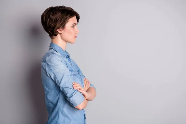 Perfil foto de atraente negócio senhora preparado ondulado bobbed penteado braços cruzados auto-confiante principal trabalhador olhar lado vazio espaço desgaste casual denim camisa isolado cinza cor fundo — Fotografia de Stock