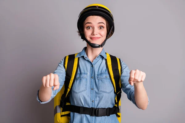 Portret van positieve koerier meisje fietser rijden denkbeeldige scooter leveren cafetaria maaltijd klant corona virus home wear denim jeans shirt helm geïsoleerd over grijze kleur achtergrond — Stockfoto