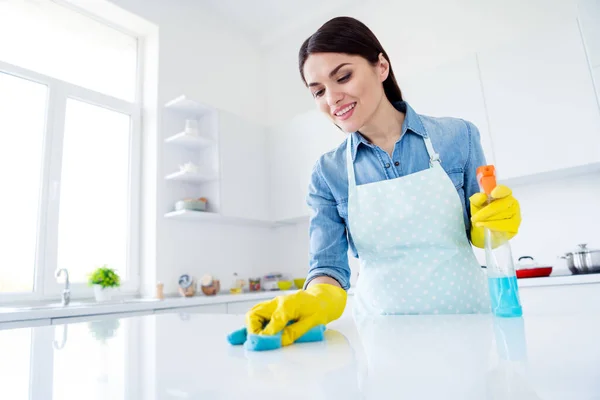 Retrato de mujer positiva trabajador profesional usar guantes de látex desinfectar mesa superficie celebrar botella pulverizador lavar trapo en casa de la cocina en interiores — Foto de Stock