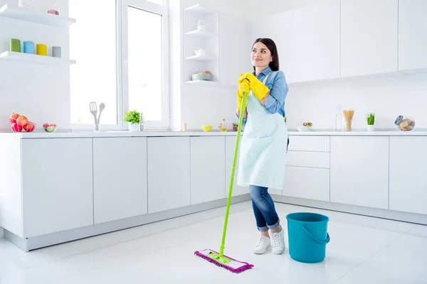 Full length body size view of her she nice attractive confident cheerful dreamy housemaid wiping neat tidy floor housekeeping stay home quarantine in modern light white interior kitchen house