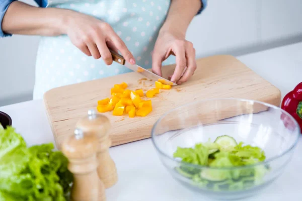 Ritagliato primo piano vista di belle mani casalinga casalinga cottura piatto piatto insalata pasto spuntino taglio pepe soggiorno casa caffè perdita di peso su tavolo in legno scrivania in luce bianco interno cucina casa — Foto Stock