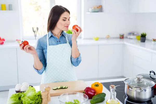 Portret van haar ze mooi aantrekkelijk vrij vrolijk dromerig meisje koken salade lunch diner schotel ruiken boerderij biologische tomaat in modern licht wit interieur keuken huis blijven thuis quarantaine — Stockfoto