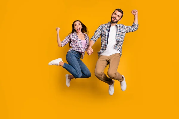 Volledige lengte foto extatische gek vrouw man sprong genieten vreugde geluk covid-19 overwinning nieuws verhogen vuisten schreeuwen ja dragen geruite geruite shirt broek geïsoleerde helder glans kleur achtergrond — Stockfoto