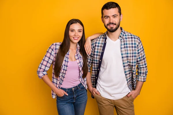 Foto atractiva dama guapo chico pareja confianza en sí mismo dos personas amistoso equipo exitosos trabajadores de pie cerca buen humor desgaste casual cuadros camisetas jeans aislado color amarillo fondo —  Fotos de Stock