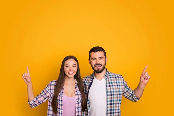 Retrato de mujer positiva hombre casado pareja punto dedo copyspace recomendar sugerir anuncios selectos promoción desgaste cuadros camisa aislada sobre brillante brillo color fondo —  Fotos de Stock