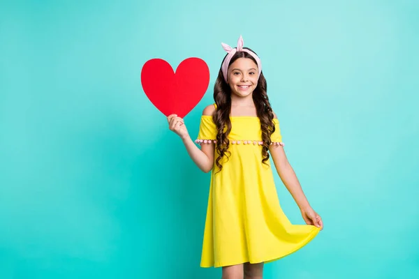 Retrato de menina positiva criança estilo vintage segurar vermelho cartão coração 14-fevereiro presente toque seu vestido vestir roupas da moda isolado sobre fundo cor teal — Fotografia de Stock