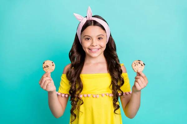 Portret pozytywnej wesoły dzieciak dziewczyna trzymać czekoladowe ciasteczka przekąska na śniadanie nosić styl modna koszula izolowane nad ciemnym tle — Zdjęcie stockowe