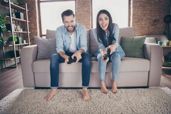 Portret van hem hij haar zij mooi aantrekkelijk verslaafd opgewonden blij vrolijk vrolijke vrienden vriendschap zitten op divan spelen videogame hobby op moderne baksteen loft industrieel interieur huis flat — Stockfoto