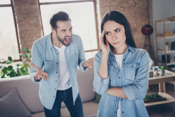 Retrato de mujer frustrada triste irritada tiene escándalo ignorar a su marido gritar que toca la cabeza de las manos cerca de sofá cómodo y acogedor en casa en el interior — Foto de Stock