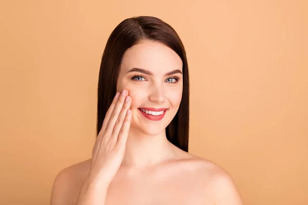 Foto de cerca de mirada de chica positiva en el espejo como su nuevo tratamiento de salón de belleza cuidado de la piel terapia de elevación para hacer su piel tez tono puro aislado sobre fondo de color beige — Foto de Stock