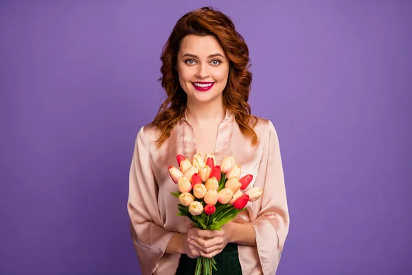 Foto de la encantadora dama sostienen ramo de flores frescas de tulipán afectuoso estado de ánimo de las mujeres día fiesta de invitados desgaste camisa beige de lujo aislado color púrpura fondo —  Fotos de Stock