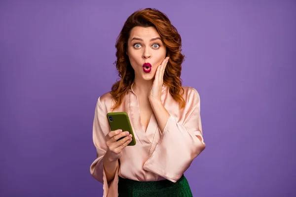 Foto van aantrekkelijke gekke freelancer dame houden telefoon gelezen bericht slecht nieuws open mond arm op wang dragen luxe beige shirt blouse geïsoleerde paarse kleur achtergrond — Stockfoto