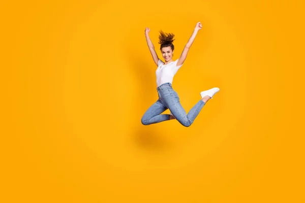 Полнометражное фото сумасшедшей женщины, прыгающей высоко на соревнованиях болельщицы марафона болельщиков команды поддержки носить белые футболки джинсы изолированные желтый яркий цвет фона — стоковое фото