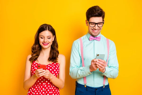 Foto di bella signora bel ragazzo tenere telefono navigazione utenti dipendenti dentino sorridente indossare rosso punteggiato abito camicia papillon isolato giallo brillante colore sfondo — Foto Stock