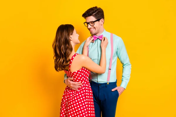 Retrato de casal positivo se preparar para a reunião da família código do vestido menina correção namorado arco-gravata desgaste vestido vermelho deotted camisa suspensórios calças isoladas sobre brilho brilhante cor fundo — Fotografia de Stock