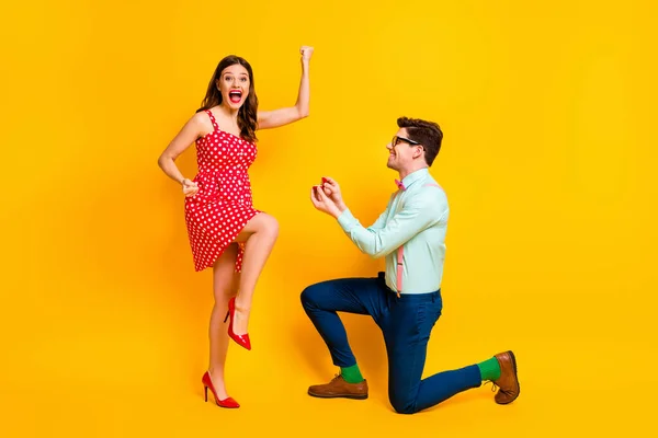 Corpo inteiro foto de pessoas de reboque estilo nerd homem propor menina extático levantar punhos desgaste vermelho pontilhado vestido de salto alto pernas mini curto suspensórios calças isoladas sobre brilhante brilho cor fundo — Fotografia de Stock