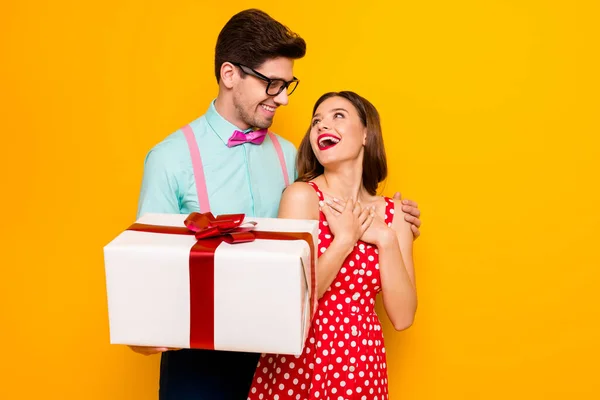 Güzel kadın, yakışıklı erkek çift, sevgilisine büyük bir hediye kutusu veriyor. 8 Mart. Hoş bir hediye. Kırmızı noktalı gömlek, yalıtılmış sarı renkli papyon pantolon. — Stok fotoğraf