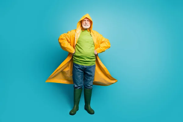 Full length body size view of his he serious content grey-haired man wearing long yellow topcoat north cycloon climate change raininy day isolated on bright vivid shine vibrant blue color background — Stockfoto