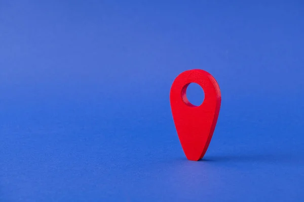一个红色指针GPS定位的特写视图找到了度假旅行预订网络应用服务的搜索位置，它在明亮、明亮、充满活力的蓝色背景下被隔离了 — 图库照片