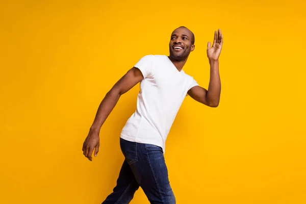 Profile side photo of charming cheerful candid afro american guy go spring walk wave hand say good bye wear trendy clothes isolated over shine color background — Stock Photo, Image