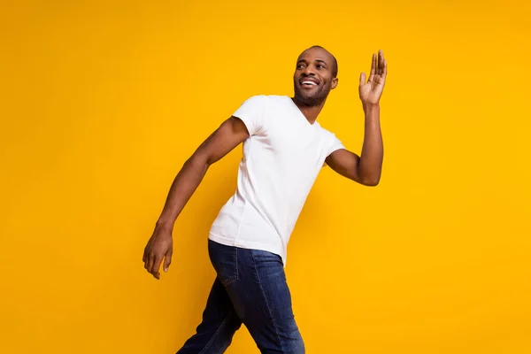 Perfil lateral foto de charmoso alegre sincero afro americano cara ir primavera andar mão onda dizer adeus usar roupas da moda isolado sobre cor de fundo brilho — Fotografia de Stock