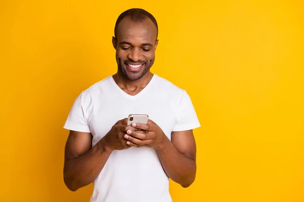 Gros plan portrait de son il beau gars joyeux gai concentré attrayant en utilisant l'appareil numérique bavarder service de date isolé sur lumineux éclat vif fond de couleur jaune vif — Photo