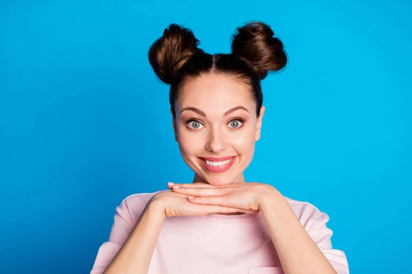 Foto de cerca de la atractiva expresión divertida dama dos bollos bonitos mirada de ensueño en los brazos de la cámara bajo la barbilla desgaste casual blanco rosa camiseta aislada de color azul brillante fondo — Foto de Stock