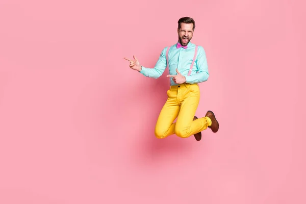 Full length body size view of his he nice atrakcyjne szalone wesoły wesoły zadowolony brunet facet artysta jumping zabawy pokazując przestrzeń najlepsze rozwiązanie odizolowany różowy pastel kolor tła — Zdjęcie stockowe