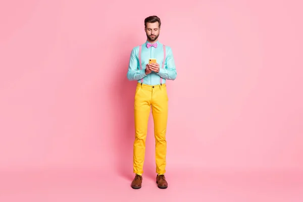 Full body photo of focused guy use cell repost share subscribe social network information wear shirt shoes isolated over pastel color background — Zdjęcie stockowe