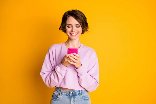 Portrait of her she nice attractive lovely pretty cute focused cheerful cheery girl using digital device chatting like share repost comment isolated bright vivid shine vibrant yellow color background