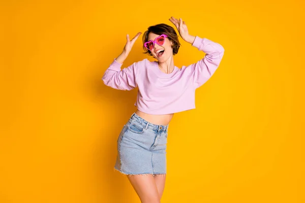Portrait of energetic carefree youth girl having heart shaped pink sunglasses enjoy weekend autumn relax raise hands wear pullover isolated over vibrant color background — Stock Photo, Image