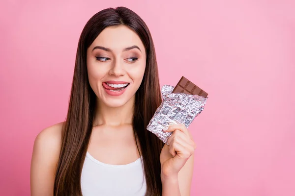 Closeup photo of funny lady hold big chocolate bar hand feel hunger licking lips want eat yummy dessert wear white singlet isolated pastel pink color background — Stock Photo, Image