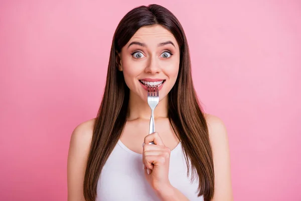 Photo of charming funny lady hold metal table fork biting teeth dreaming of tasty food dinner big desire eyes wear casual white singlet isolated pastel pink color background — Stock Photo, Image