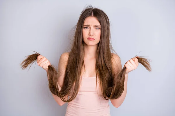 Close-up ritratto di bella attraente piuttosto depresso triste malessere malsana ragazza dai capelli castani tenendo in mano estremità asciutte soluzione condizionatore lozione rimedio isolato su sfondo grigio chiaro colore pastello — Foto Stock