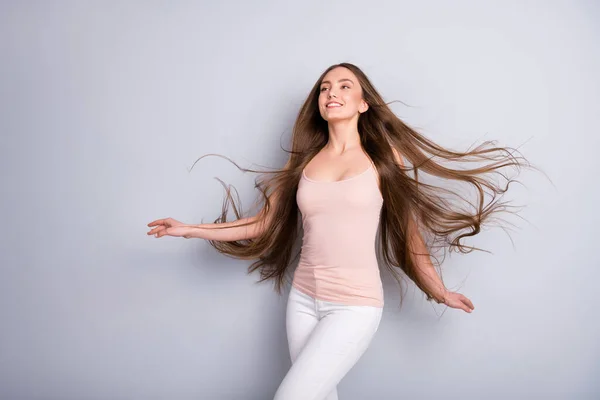 Foto de atractiva dama demostrando ideal limpio largo y saludable peinado volando en el aire después de caminar salón calle elegante desgaste beige singlet blanco pantalones aislados color gris fondo —  Fotos de Stock