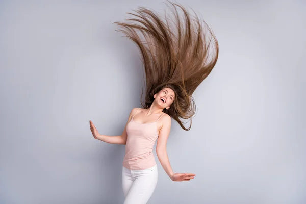 Photo of attractive charming model lady demonstrują idealne zadbane długie zdrowe fryzury latające na powietrzu po zabiegu salon nosić beżowe spodnie singlet odizolowany szary kolor tła — Zdjęcie stockowe