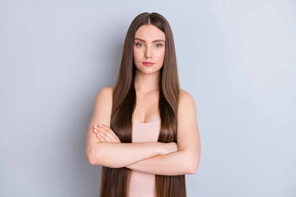 Foto de increíble apariencia perfecta modelo señora no sonriendo presentando ideal limpio largo peinado brazos cruzados desgaste beige singlet aislado gris color fondo —  Fotos de Stock