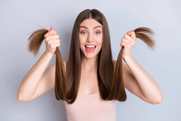 Foto van opgewonden mooie model dame houd handen lang kapsel krullen uiteinden goede conditie tonen goede nieuwe masker effect slijtage beige singlet geïsoleerde grijze kleur achtergrond — Stockfoto