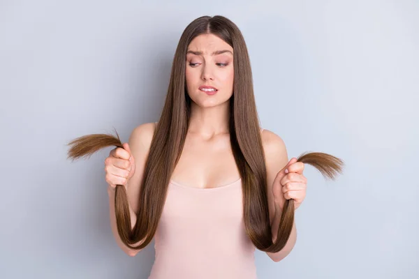 Foto van perfecte verschijning model dame houd handen lang kapsel krullen uiteinden bijten lippen gespleten beschadigde toestand slecht masker effect slijtage beige singlet geïsoleerde grijze kleur achtergrond — Stockfoto