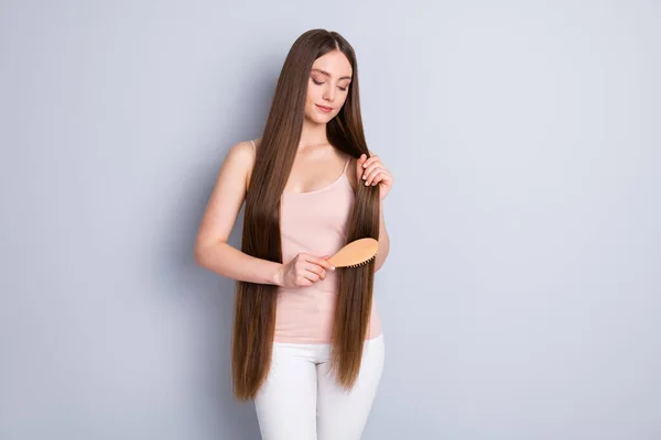 Foto van perfecte verschijning model dame lang kapsel hold favoriete houten kam borstelen sterke krullen dragen beige singlet broek geïsoleerde grijze kleur achtergrond — Stockfoto