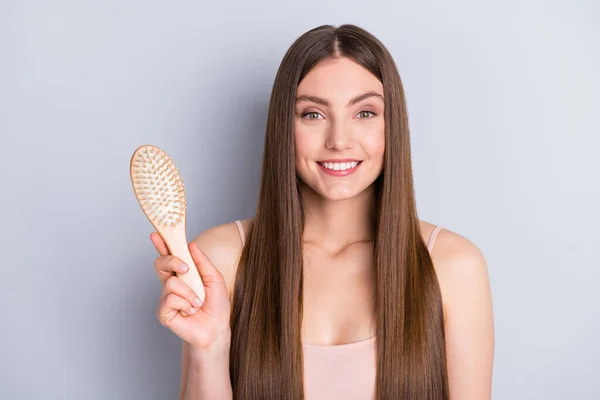 Foto von attraktiven perfektes Aussehen Modell Dame lange erstaunliche Frisur zeigen Lieblings-Holzkamm tragen beige Singlet isoliert graue Farbe Hintergrund — Stockfoto