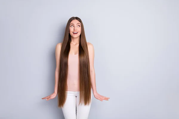 Foto des charmanten Aussehens Modell Dame demonstriert ideal ordentlich lange Frisur aussehen interessiert Seite leer Raum tragen Singlet weiße Hosen isoliert graue Farbe Hintergrund — Stockfoto