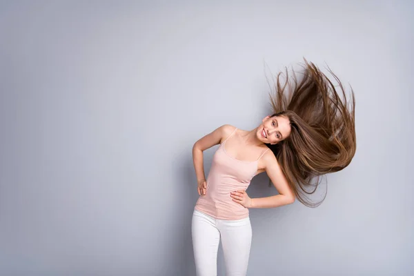 Photo of attractive model lady demonstrate ideal groomed long healthy hairstyle flying on air after salon procedure arms by sides wear beige singlet pants isolated grey color background Stock Image