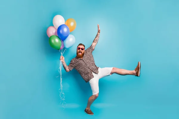 Full size foto van gekke luxe persoon man houden veel kleurrijke lucht ballonnen feestelijke gebeurtenis partij verhogen hand been dragen luipaard shirt zon specs schoenen shorts geïsoleerde blauwe achtergrond — Stockfoto