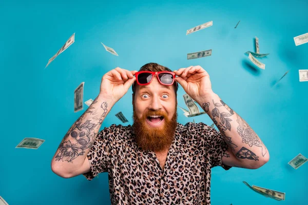 Photo of excited emotional macho guy luxury rich person dollars fall from sky income lottery cashback open mouth win money wear leopard shirt sun specs isolated blue background — Stock Photo, Image