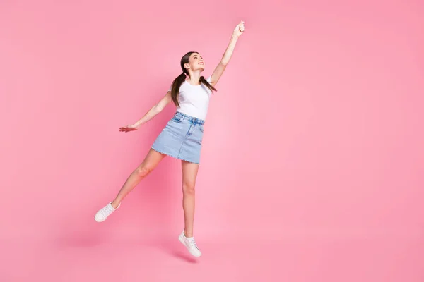 Full body foto van mooie dame springen hoge vangst voorstellen paraplu vliegen met wind dragen casual wit t-shirt mini denim rok schoenen geïsoleerde pastel roze kleur achtergrond — Stockfoto