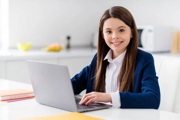 Fénykép a kis vidám csinos diák lány szorgalmas diák notebook online lecke videó hívás sit desk távolság karantén tanulmány szeptemberben otthon nappali ház osztályterem beltéri — Stock Fotó