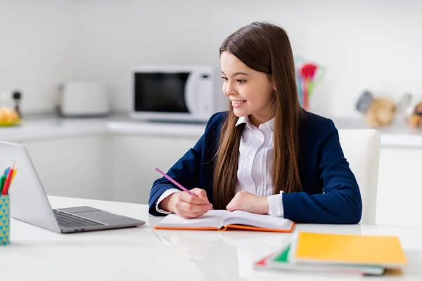 小さなかわいい学生の女の子の勤勉な学生ノートブックオンラインレッスンビデオコール座る机書き込みノート教師が言った距離隔離学習キッチン教室室内 — ストック写真